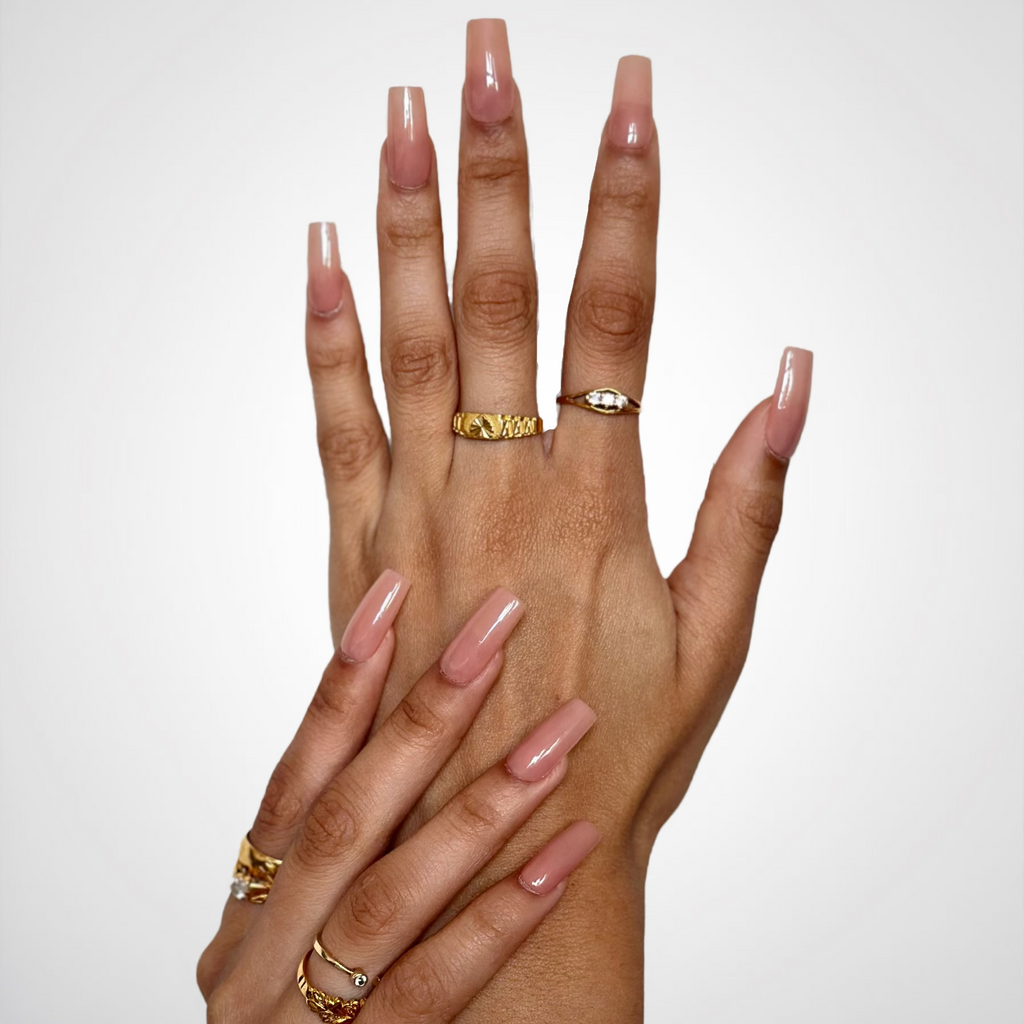 long, square-shaped nude pink manicured nails.